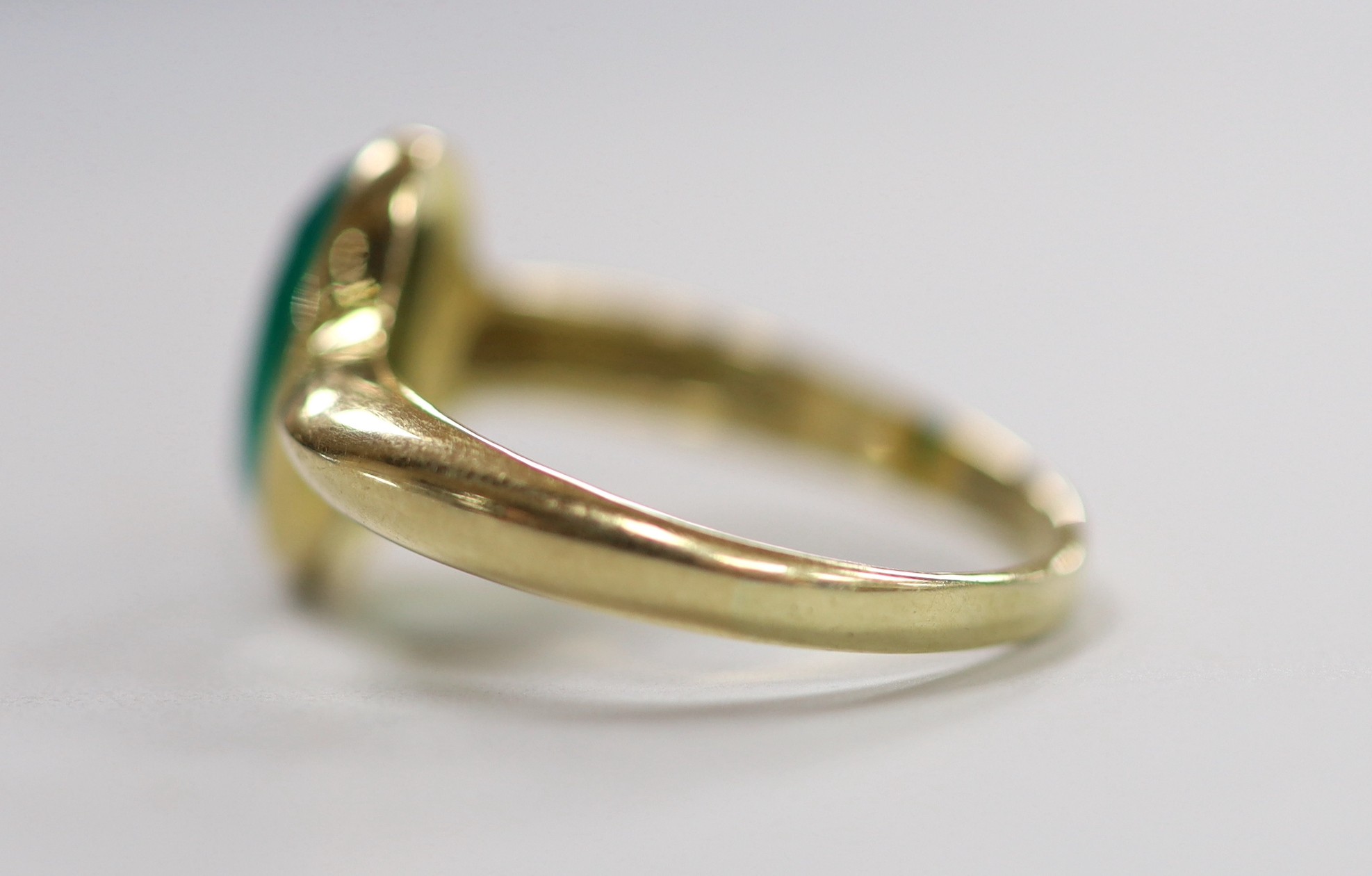 A modern yellow metal and single stone facetted oval chrysoprase set ring, size S, gross weight 3.7 grams.